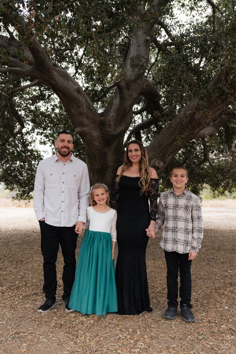 Maryam Fraser, owner of Fraser Daycare and Preschool, with her husband and their two children under an oak tree